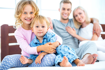 Obraz premium Young family lying on white bed