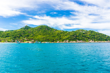 Fototapeta na wymiar Rocky island with Turquoise Water and Green Palm Trees