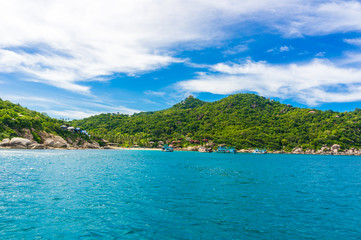 Fototapeta na wymiar Rocky island with Turquoise Water and Green Palm Trees