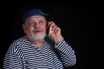 Elderly man joy as a kid listening sounds of sea shells