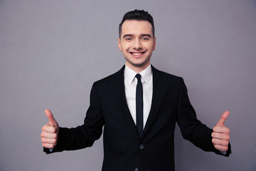 Smiling businessman showing thumbs up