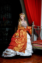 Retro baroque fashion blonde woman wearing gold dress.