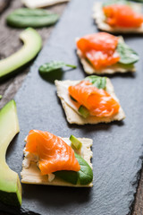 Crackers with cream cheese smoked salmon and avocado