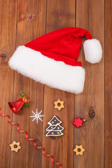 Obraz na płótnie Canvas Hat of Santa Claus and Christmas balls on wooden table.