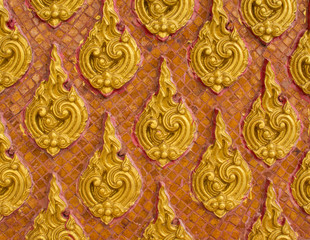 Fototapeta na wymiar golden thai style stucco on wall in temple