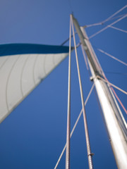 Yacht mast and sail with a blue sky backdrop