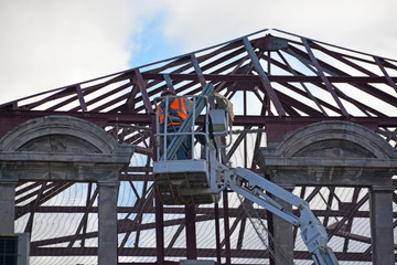 obrero trabajando sobre una gr&uacute;a