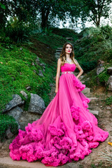 Beautiful woman in gorgeous pink dress outdoors . Full length Portrait.