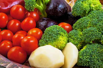 Vegetables on a plate. Broccoli, peeled raw potatoes, peeled boiled beets, red peppers, cherry tomatoes