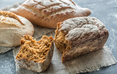 Whole grain breads on the dark wooden background
