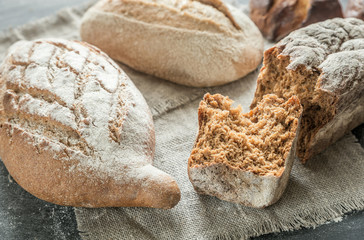 Whole grain breads on the dark wooden background