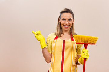 Housewife with broom pointing at your product