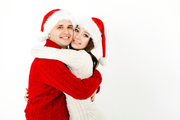 Happy embracing couple in Christmas caps