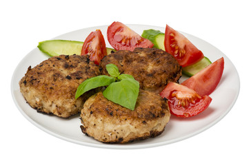 Roasted cutlets with tomatoes and cucumbers on the white  plate isolated.