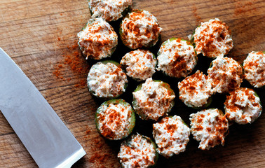 Festive appetizer hollow cucumber filled with king crab and garnished with paprika