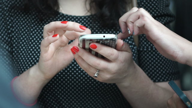 Young Woman smiling and texting on her mobile phone