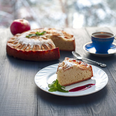 Piece of apple pie on plate, tea cup