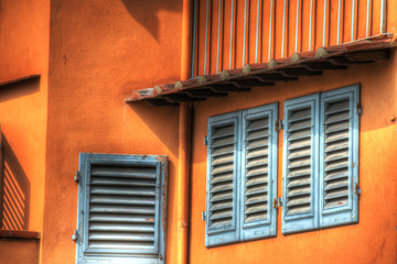 close up of windows in an orange wall in Florence