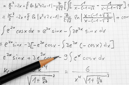 Maths concept - handheld calculator and pencil over a sheet of paper with maths-formulas