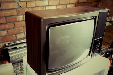 Old analogue television white screen on a brick warehouse