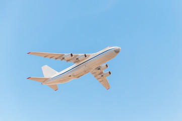 An-124-100 Ruslan (Condor) the world largest cargo strategic airlift jet airplane flies against blue sky background.
