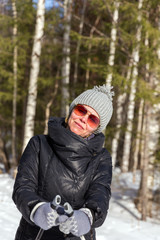 Happy young woman skiing in the winter forest