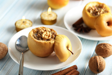 Baked apples on plate on blue wooden table