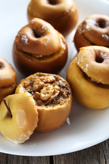 Baked apples on plate on grey wooden table