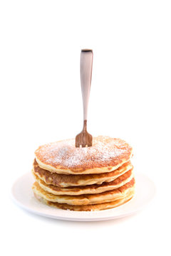 Pancakes isolated on white background with  a fork stuck in them