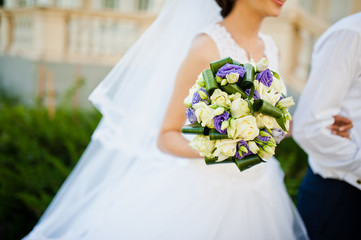 Violet wedding bouquet on hand of bride