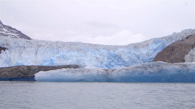 A glacier in Greenland stretching across shoreline. Slow Motion