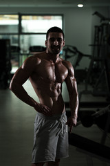 Fototapeta na wymiar Bodybuilder Man Posing In The Gym