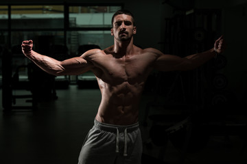 Obraz na płótnie Canvas Bodybuilder Posing In The Gym