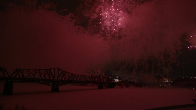Slow motion fireworks over Alexandria Bridge crossing the Ottawa River during Winterlude.