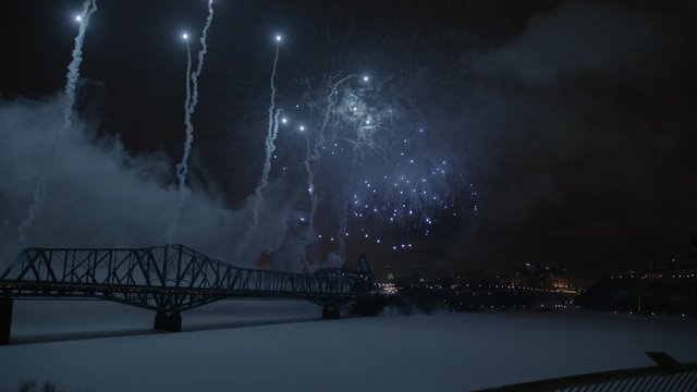 Slow motion fireworks over Alexandria Bridge crossing the Ottawa River during Winterlude.