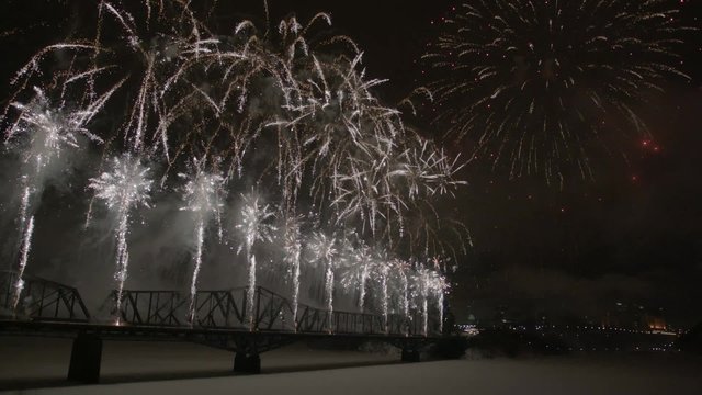 Slow motion fireworks over Alexandria Bridge crossing the Ottawa River during Winterlude.
