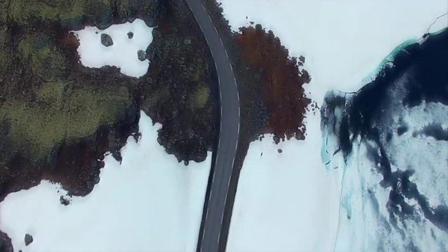 Aurlandsfjellet mountain pass road viewed from air, popular tourist route in Norway carving its way through snowy landscape. Aerial 4k Ultra HD.