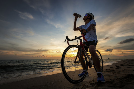 Drinking, cycling concept outdoors against sunset