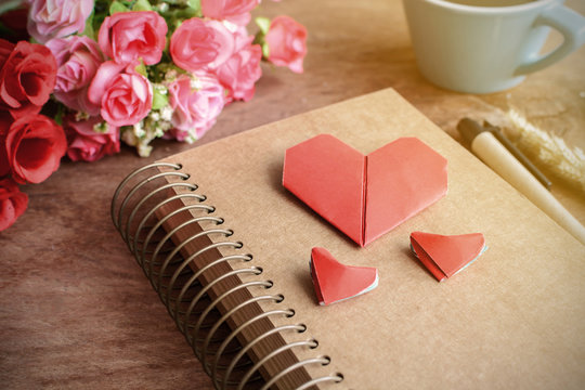 Cup of coffee with flower and red heart shape paper and notepad
