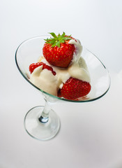 strawberries and cream in a glass on a white background