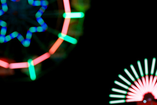 Defocused and blurred image of ferris wheel at amusement park at
