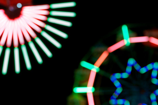 Defocused and blurred image of ferris wheel at amusement park at