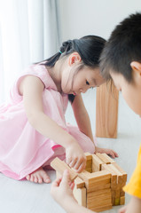 Obraz na płótnie Canvas Asian children playing wooden blocks at home.