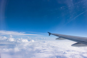 Wing of an airplane flying above the clouds. people looks at the