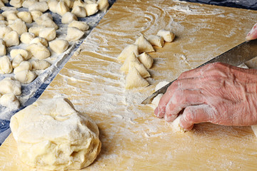 mani che tagliano l'impasto per i gnocchi