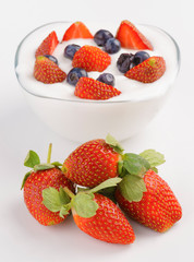 bowl full of yogurt with blueberries and strawberries
