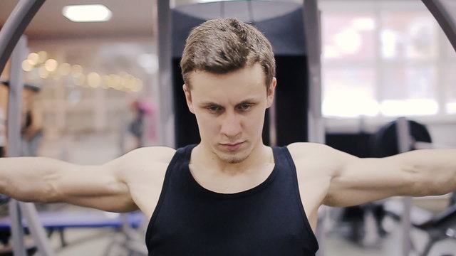 Man in gym on machine exercising slow motion