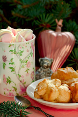 Obraz na płótnie Canvas Choux pastries with soft cheese and raisins filling (Ukrainian traditional pastry Mryya), hot chocolate with marshmallows served on the table with Christmas and New Year Decoration on the background