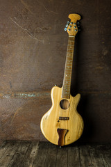 Fototapeta na wymiar Acoustic guitar resting against an old steel background