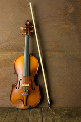 Fototapeta na wymiar vintage violin resting against an old steel background